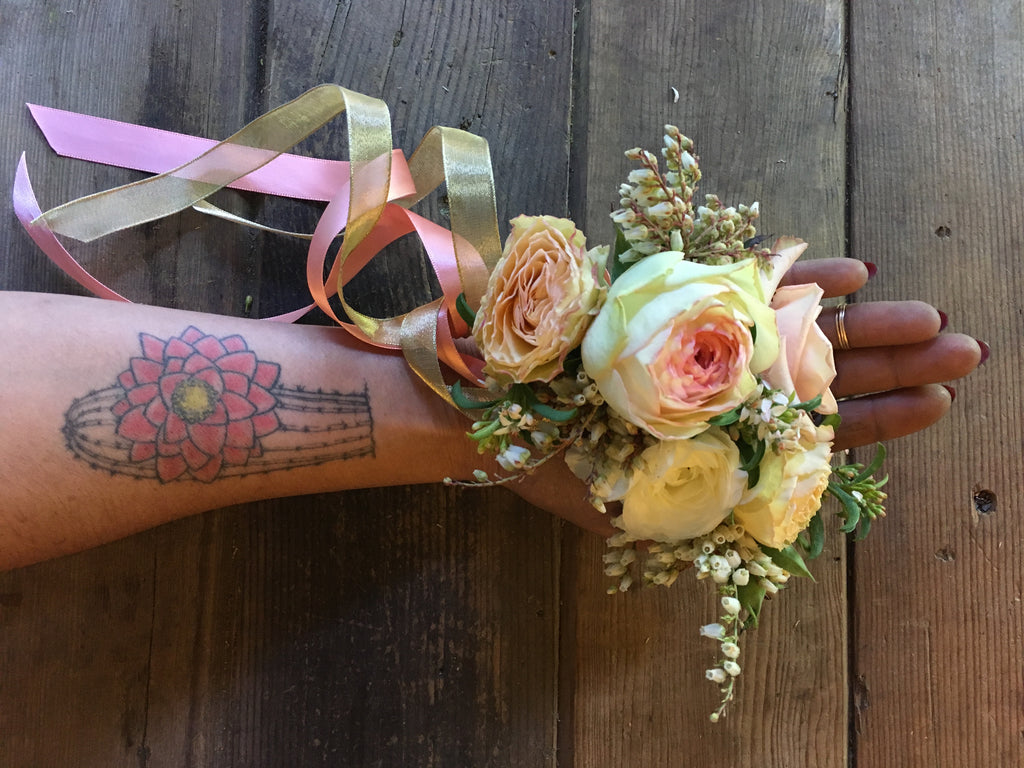 Photo of Pilar Zuniga's arm holding out a wrist corsage for a Gorgeous and Green wedding